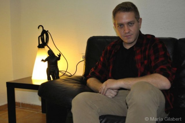 Octavio López posa junto a una figura de Godzilla - © María Gilabert / Alicante Mag